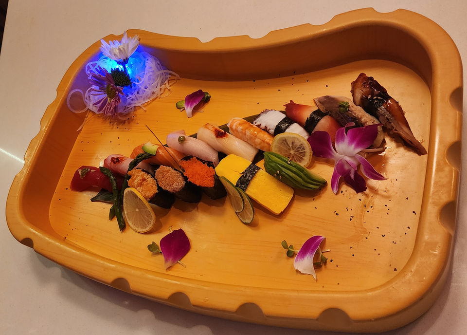 Variety of colorful sushi on a decorative wooden serving platter arrangement