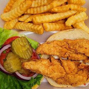 炸鱼薯条汉堡，配有生菜、番茄、洋葱和泡菜。美食的特写镜头。