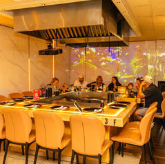 Customers dining at a restaurant, lit by neon lights, with the number 3 F.