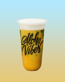 Yellow drink in a cup with Aloha Vibes printed on it.