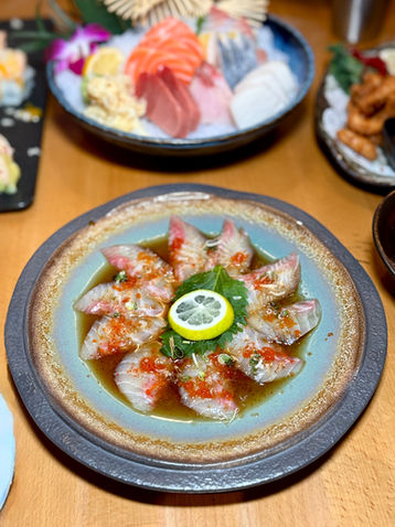 Delicious sushi dish with lemon and sauce, Yoi Sushi on the table.