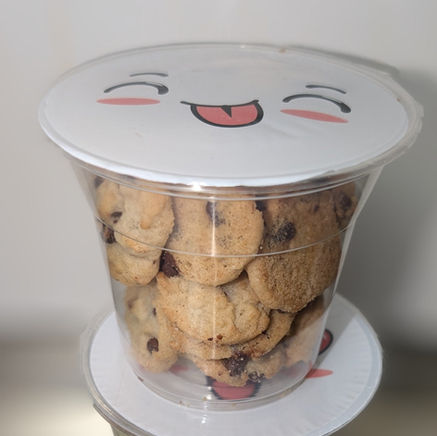 一杯装满巧克力饼干的透明杯子,带有可爱表情的盖子。