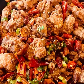 美味的炸鸡块,配有辣椒和葱花。看起来像一道美味的菜肴。