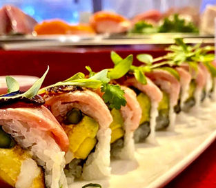 美味寿司卷，食材新鲜。绿色植物点缀，背景是更多寿司，美味诱人，BAMBOO HYANNIS。