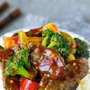 Beef and broccoli stir fry with baby corn and red pepper on plate
