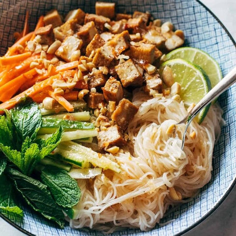 Delicious Asian noodle bowl with tofu, vegetables, and peanuts in a bowl