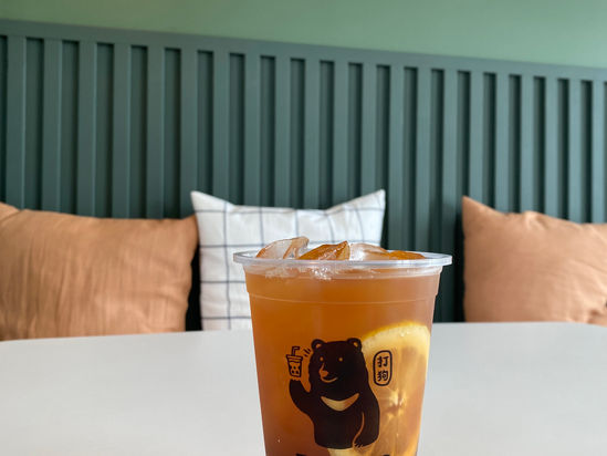 Iced tea with lemon and Takao Tea logo on a table.