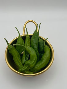 Green chili peppers in a gold bowl