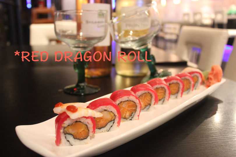 Red Dragon Roll sushi on a white plate with text Sakura Asian Bistro HOME