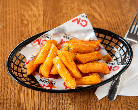 Spicy tteokbokki CM Chicken Korean food dish on black basket, on table