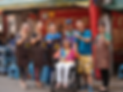 Smiling street vendors and an elderly woman in a wheelchair.
