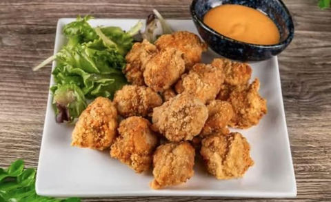 炸鸡块配酱汁和蔬菜，美味可口的小吃，适合分享和食用。