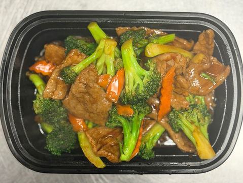 Beef and broccoli stir-fry in a black container with carrots and sauce.