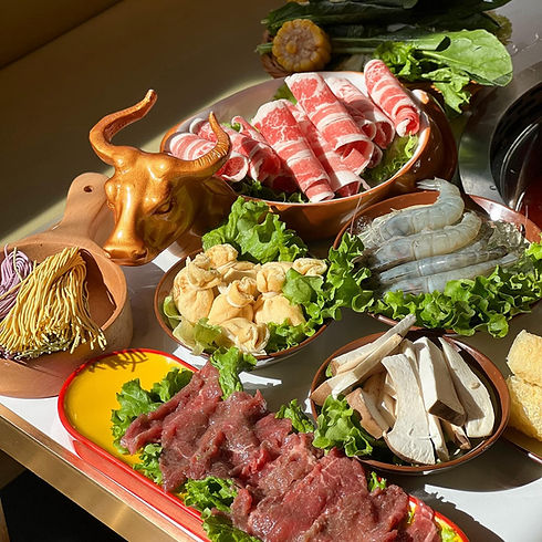 Raw hot pot ingredients: sliced beef, lamb, shrimp, noodles, mushrooms.