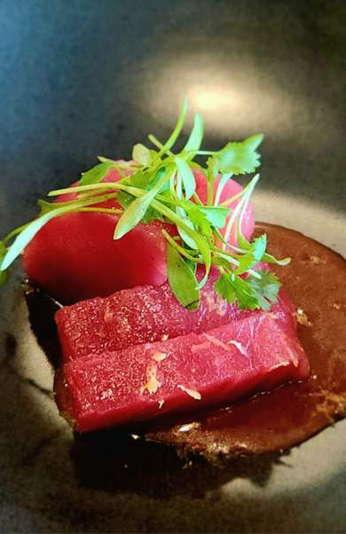 Close-up of a plate with beetroot, garnish, and Sushi The Classic.
