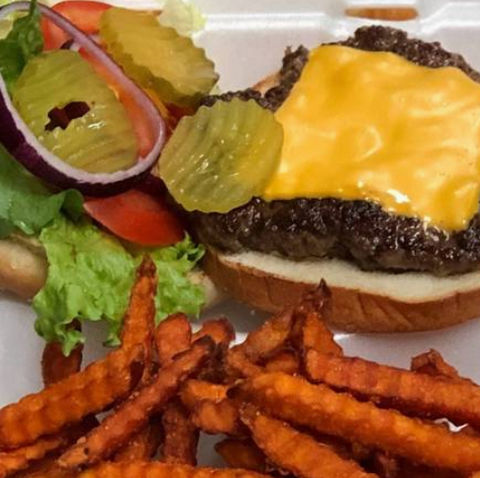 芝士汉堡配薯条和酸黄瓜，配有蔬菜，美味可口，诱人食欲。