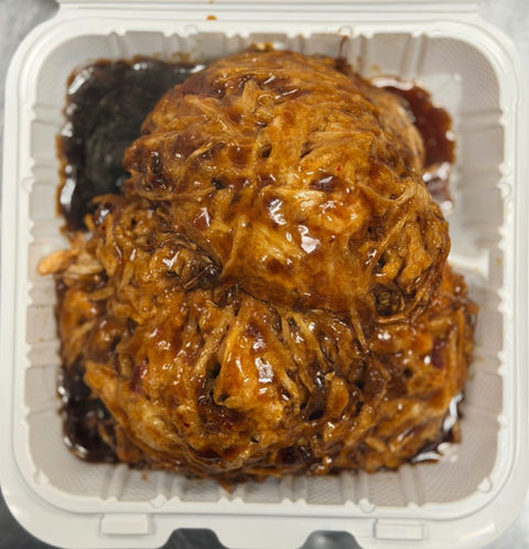 Pulled pork in a to-go container with a dark sauce.