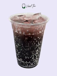 Iced beverage with ice and Vessel Tea logo, on a plain background.