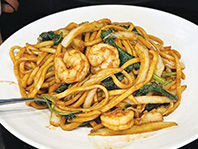 盘子里的虾仁炒面,美味的虾和面条,配有蔬菜,看起来很可口。