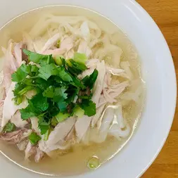 碗里的鸡肉河粉，配以香菜和葱，美味可口的鸡肉河粉，享用吧！