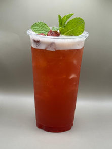 Refreshing iced red tea with creamy foam, fresh mint, and berries.