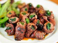 Delicious beef rolls with spinach and sauce arranged on a white plate