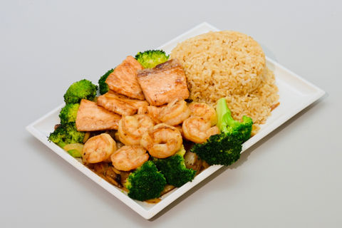 A plate of cooked salmon, shrimp, broccoli, and brown rice