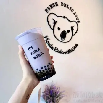Hand holding a Koala Bakery & Cafe drink with It's Koala World text.