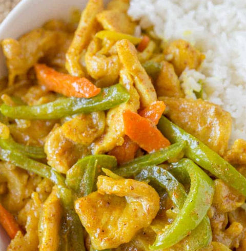 Chicken stir-fry with rice, green peppers, carrots and yellow curry sauce.