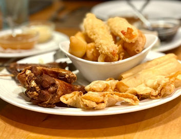 各种炸食品拼盘，包括炸鸡、虾和春卷，放在盘中准备食用