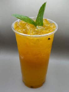 Refreshing orange iced drink with passion fruit and green leaves.
