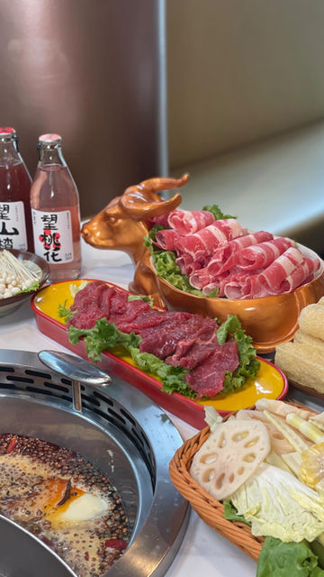Sliced raw beef, lamb, vegetables for hotpot, pink bottles "山" and "花".