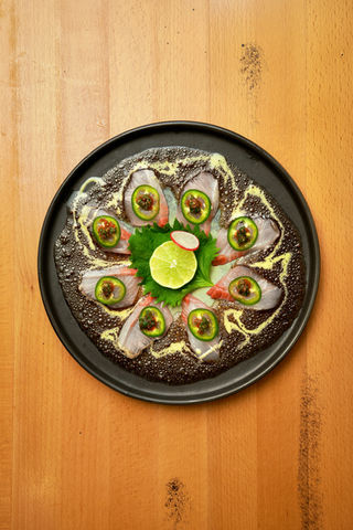 Sushi plate with fish, jalapeños, lime, and sauce; Yoi Sushi.