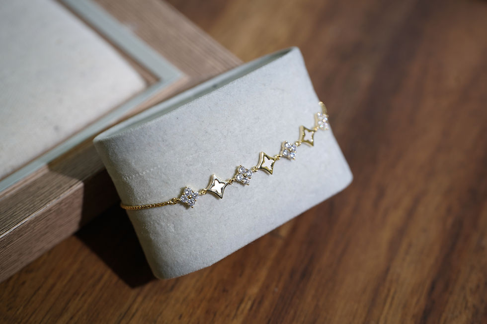 This bracelet features a cross-flower design, mother-of-pearl and zircon stones