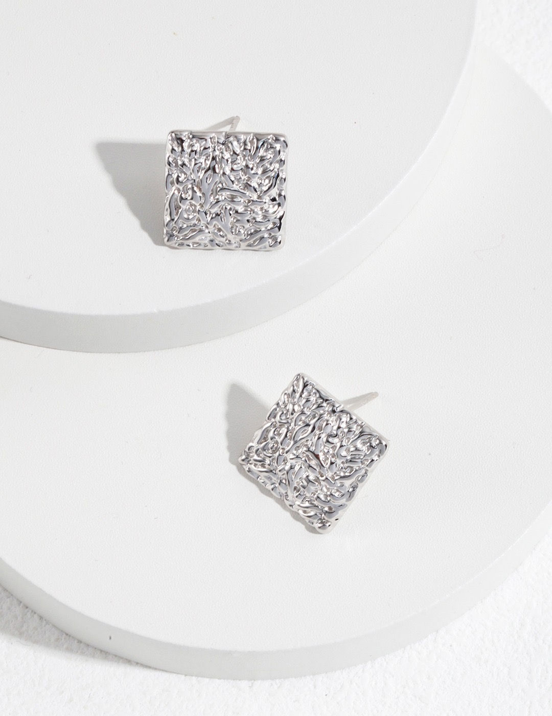 minimalist silver earrings featuring a square folded pattern