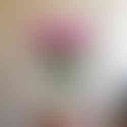 A bouquet of pink flowers and pale peach roses in a glass vase