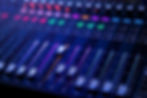 Imagem do painel de controle profissional do mixer de som e áudio com botões e controles deslizantes.