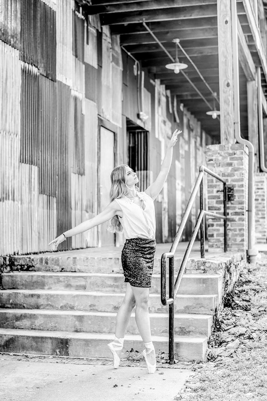 Black-and-white senior portrait in rustic city location