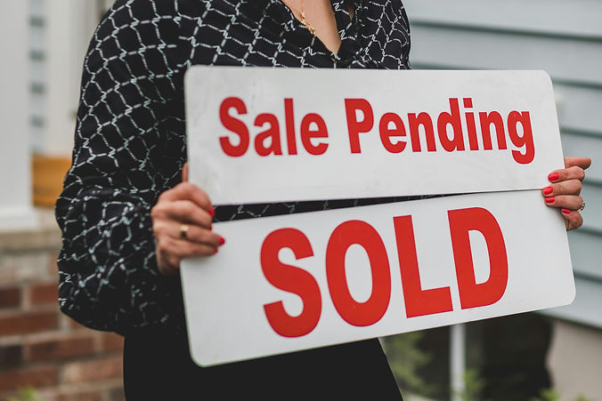Real Estate Agent Holding a for sale and sold sign