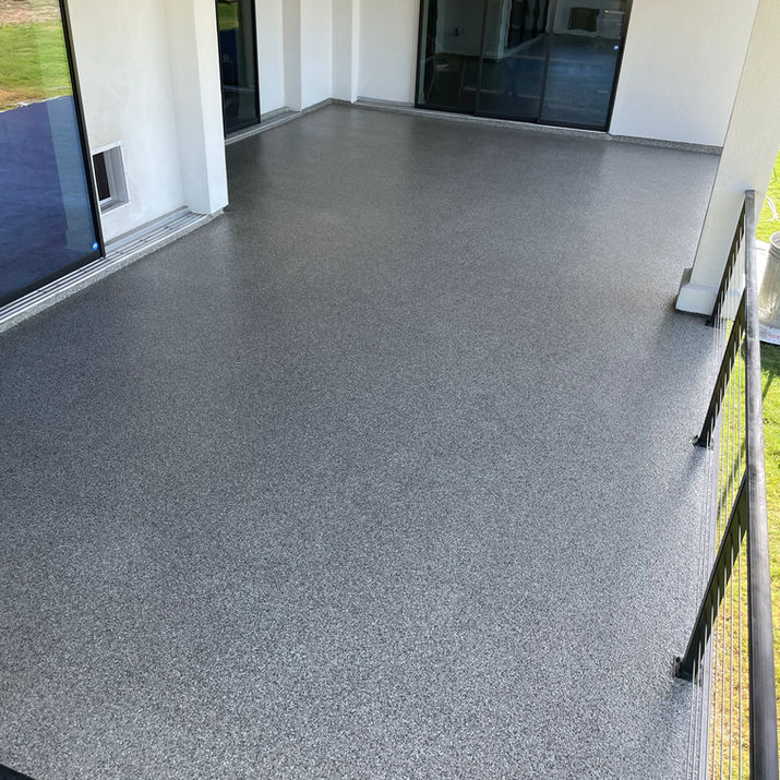 Full-broadcast epoxy flake flooring for a garage and covered patio in Pflugerville, TX, featuring a high-gloss, slip-resistant polyaspartic topcoat.