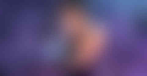 Romantic visual novel scene of a muscular samurai embracing and kissing a blue-skinned oni with long dark hair and red markings. The oni clings tightly to him, eyes closed, while the samurai holds him firmly with one arm. They are in a misty hot spring at night, glowing purple light adding to the intimate atmosphere. A text box at the bottom contains narration about surrendering to the oni’s tenderness.