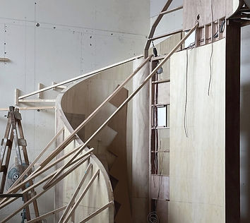 On a construction site observing the building process of a spiral staircase, highlighting structural details and craftsmanshi