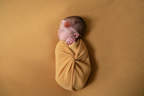 baby wrapped in sunflower yellow wrap