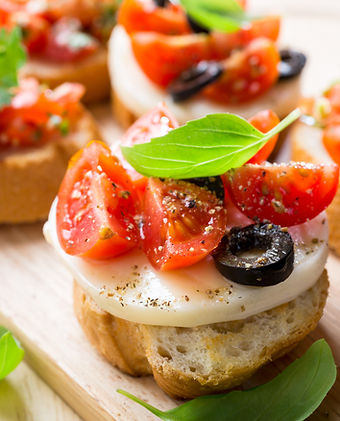 Assorted appetizers including bruschetta and spring rolls
