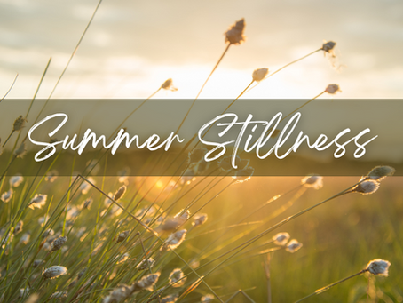 Words "Summer Stillness" over a field at sunset