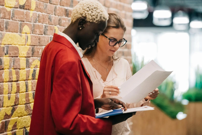 Two women checking documents.