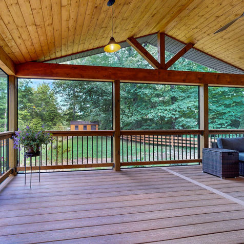 Deck and covered porch in Hendersonville, NC with Fiberon Sanctuary composite decking, wood railing with bronze aluminum balusters, and cedar tongue-and-groove ceiling.