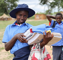 An ACFE student after receiving stationery and school uniforms
