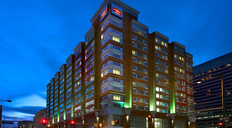 Exterior view of the Residence Inn by Marriott Denver City Center, illuminated against the evening sky, showcasing its modern architectural design and inviting atmosphere.