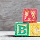 Color letter block in word abc on wood background.jpg